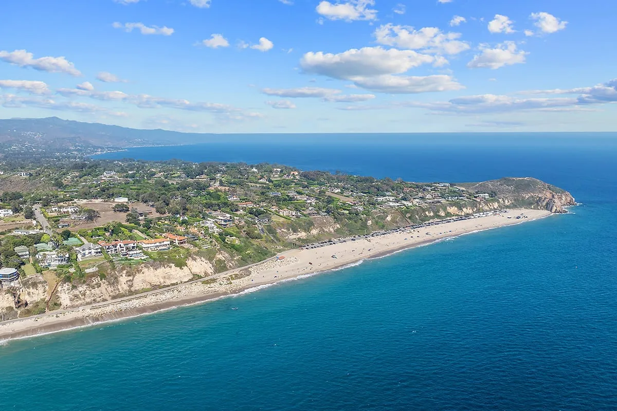 Aerial view of the Point Dume headland, a sandy beach and the blue Pacific Ocean in Malibu