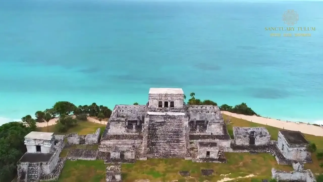 Aerial view of the Mayan ruins of Tulum on a green clifftop above a turquoise Caribbean sea