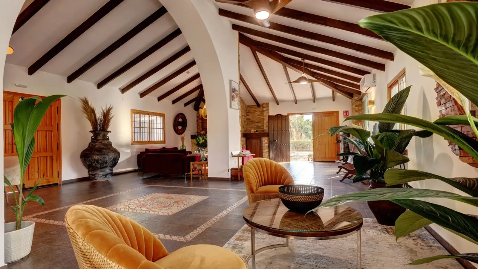 Living room at Hacienda Paradiso with arched ceilings, wooden beams and velvet armchairs, Málaga, Spain